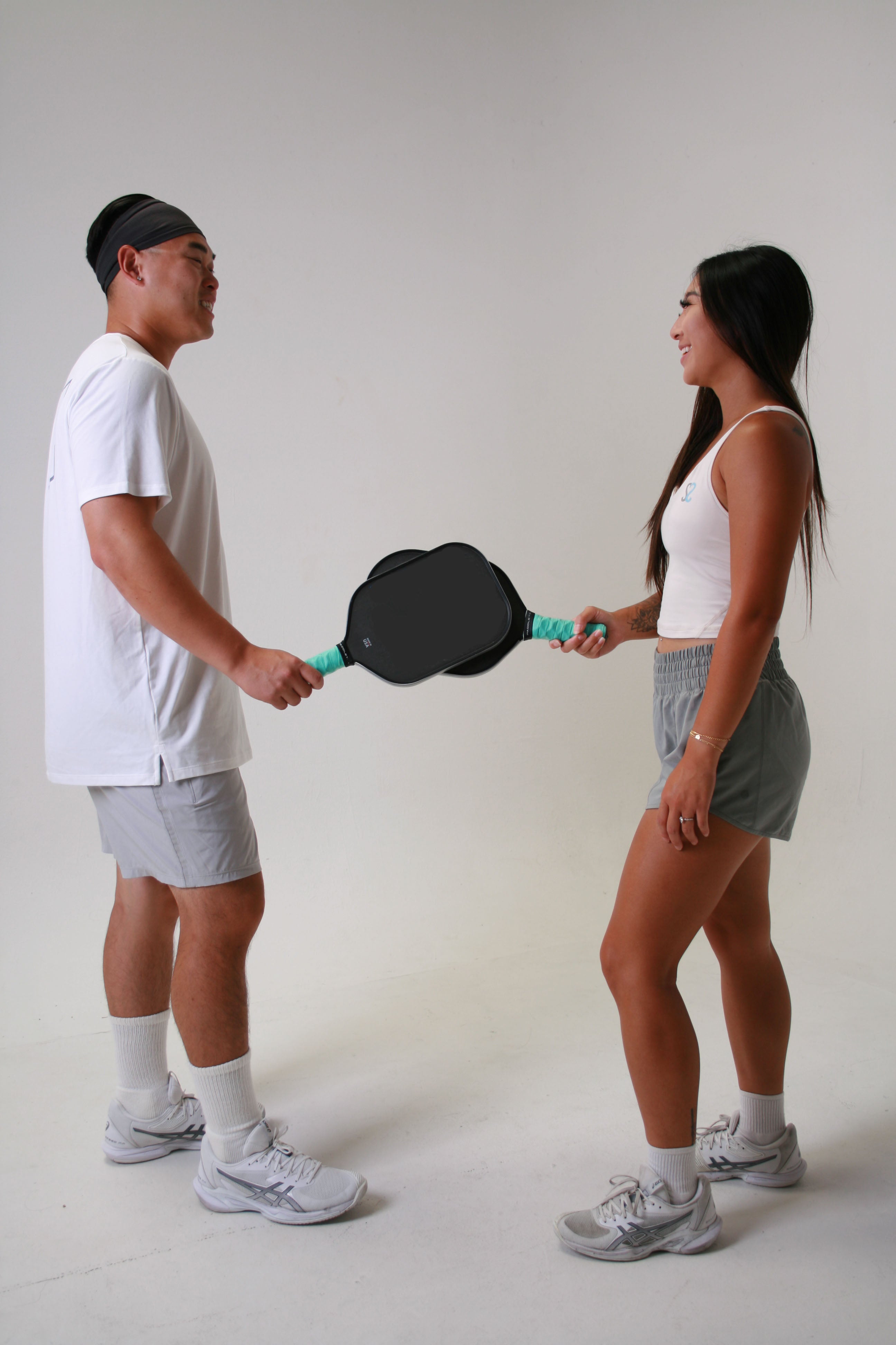 Steven and Stacey touching paddles smiling at each other